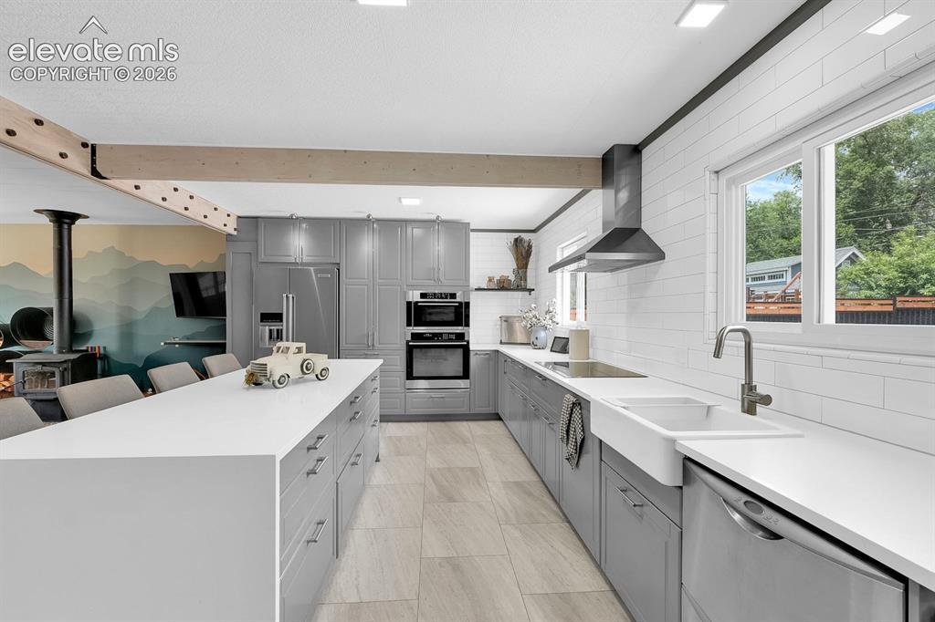 Image 7 of 33: Modern kitchen featuring a large center island with ample storage, grey cab