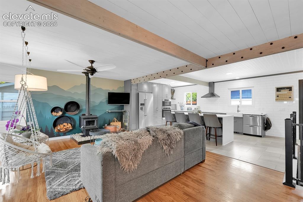 Image 9 of 33: Open-concept living space featuring wood-finish flooring, exposed wood beam