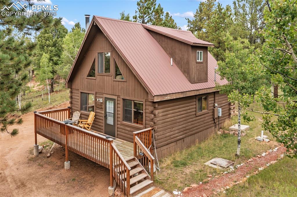 Caption: Front of property featuring a metal roof, log siding, a deck, and deck with vews!