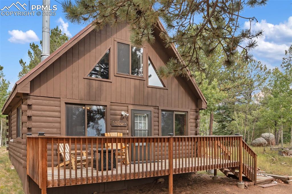 Image 3 of 45: Front of house with a deck and log siding