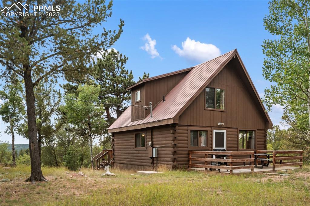 Image 45 of 45: Back of property featuring a metal roof and log siding