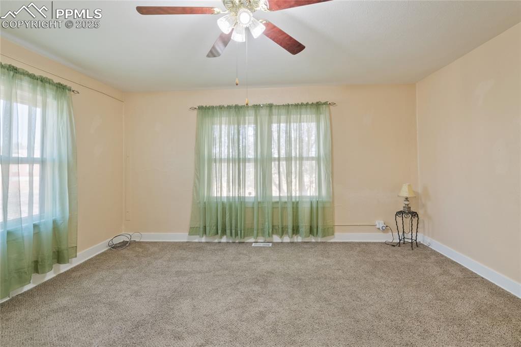 Image 10 of 28: Carpeted empty room featuring ceiling fan and baseboards