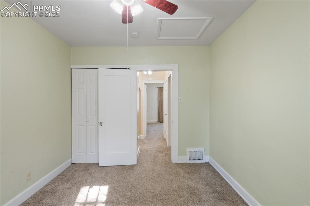 Image 24 of 28: Unfurnished bedroom featuring attic access, carpet floors, a closet, and ce