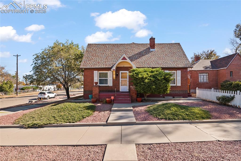 Image 5 of 28: View of front of house featuring brick siding and a chimney
