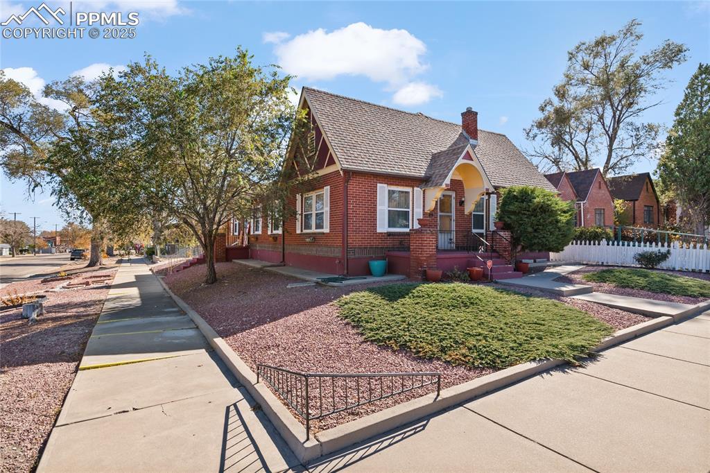 Image 6 of 28: Tudor home with brick siding and a chimney