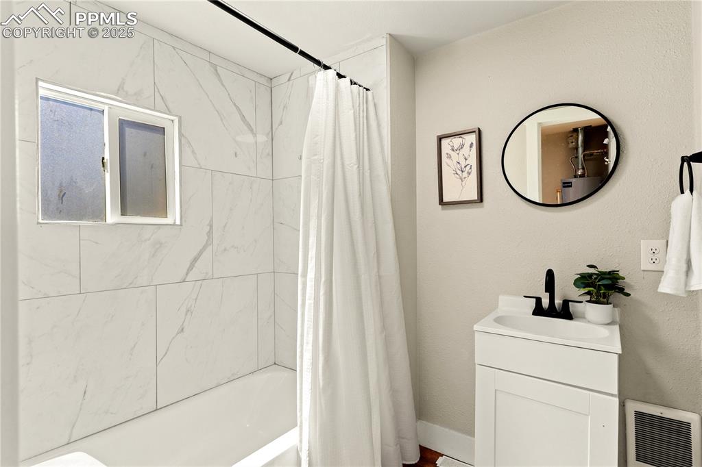Image 12 of 13: Full bath with vanity and shower / bath combo with shower curtain