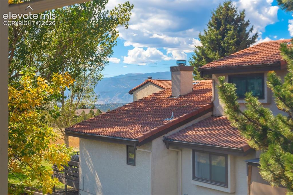 Image 27 of 50: Terracotta tile roofing, stucco exterior, and multi-pane windows