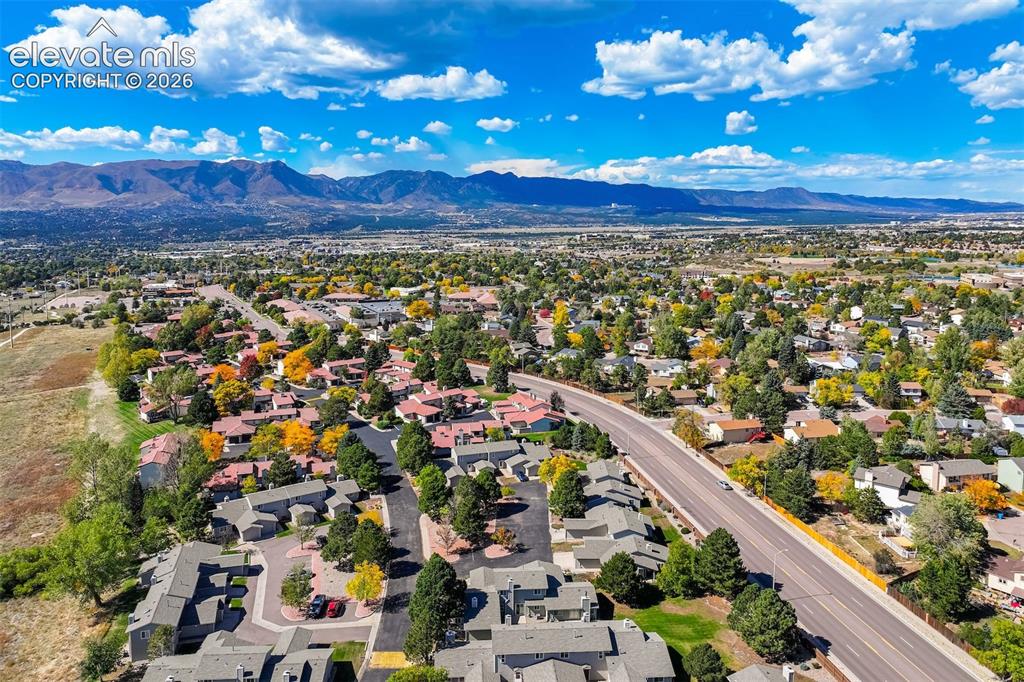 Image 37 of 50: Expansive community with varied architecture, mature trees, and mountain sc