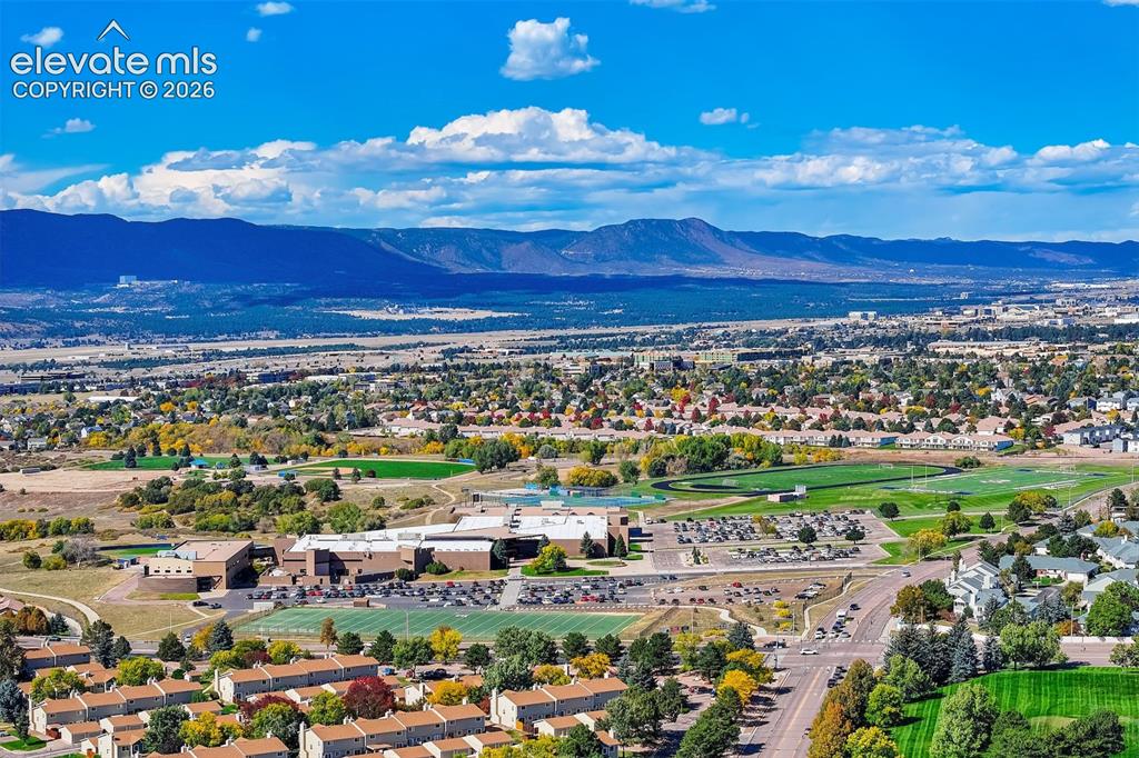 Image 42 of 50: Expansive mountain backdrop with a broad urban landscape featuring diverse 