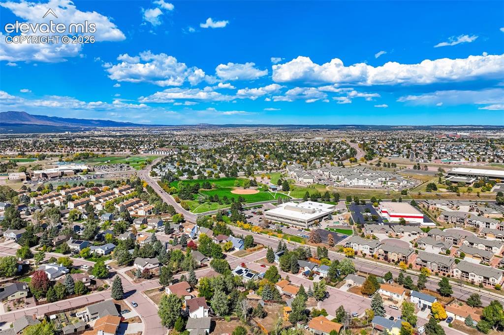 Image 43 of 50: Expansive neighborhood with mature trees, green spaces, and mountain backdr