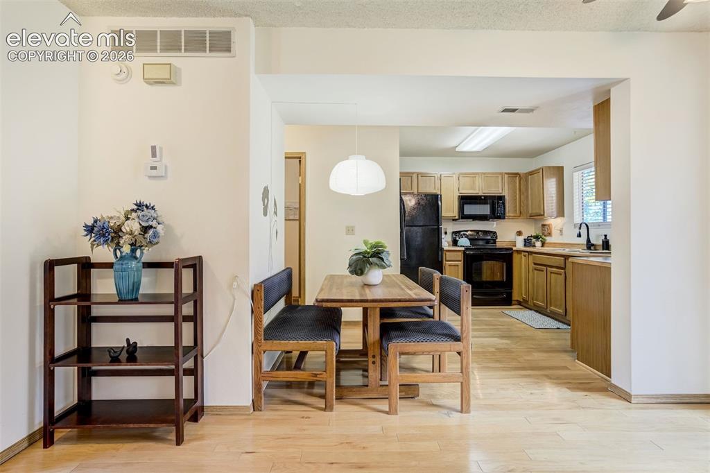 Image 9 of 50: Wood-finish flooring throughout, with a dining area featuring a contemporar