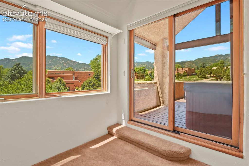 Image 16 of 39: Walk out to deck with hot tub & panoramic mtn views