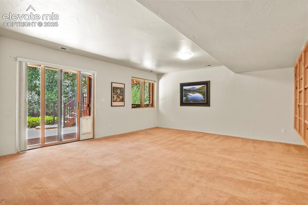 Image 24 of 39: Lower level walk out to beautiful fenced back yard with flagstone patio
