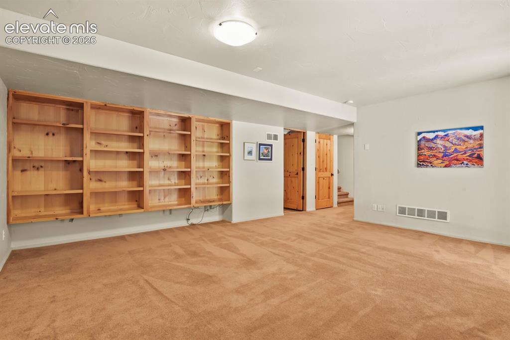 Image 25 of 39: Lower level with built in bookshelves