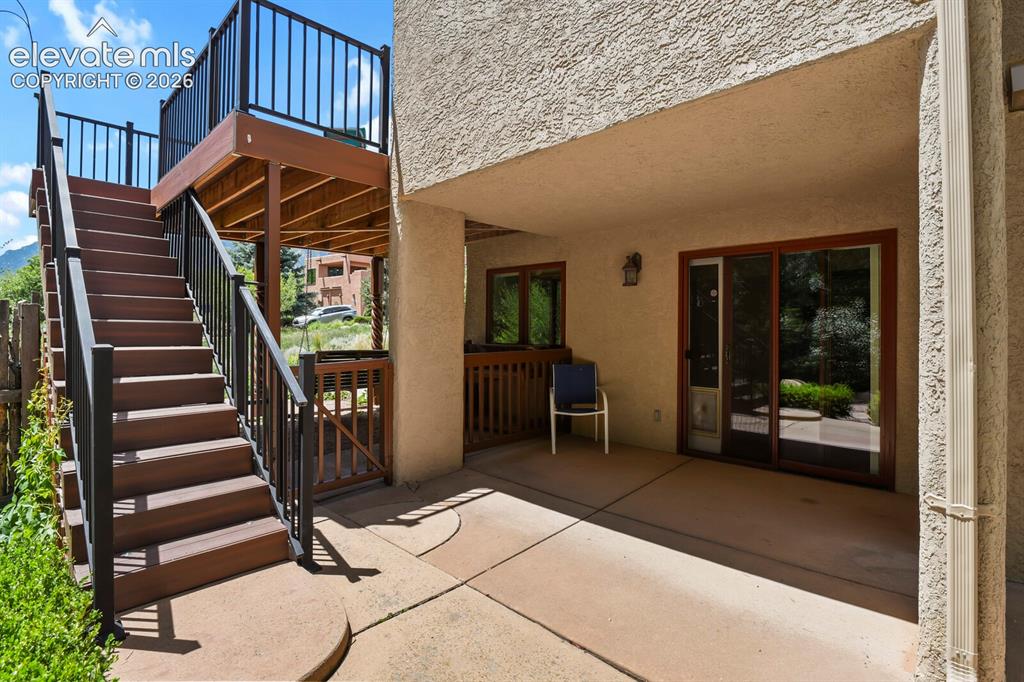 Image 27 of 39: Steps from main deck to Lower patio in rear