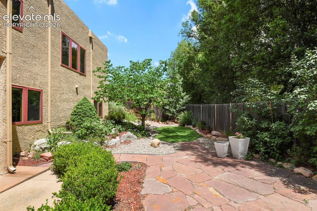 Image 29 of 39: Rear flagstone patio in fenced backyard