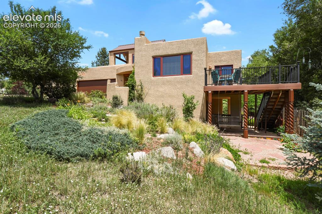 Image 4 of 39: Deck off dining area, lots of perennials & pretty landscaping