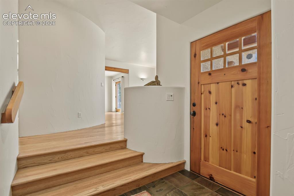 Image 5 of 39: Slate entry with hardwood steps to main level
