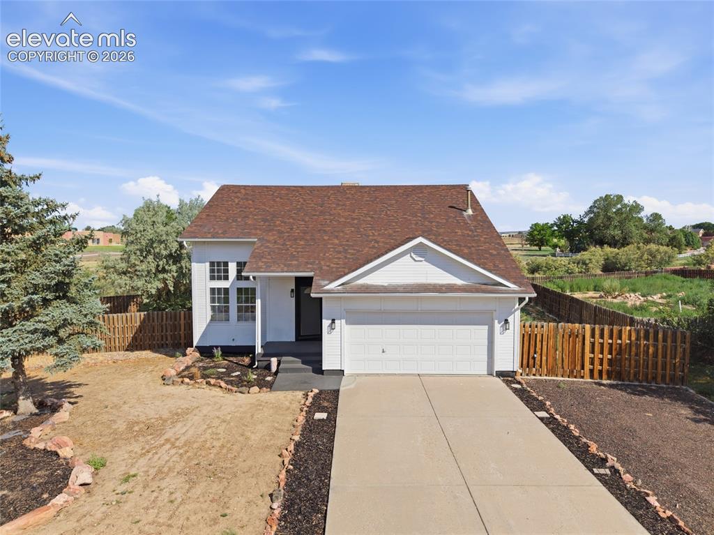 Image 1 of 40: Contemporary residence featuring a two-car garage, white siding, and a brow