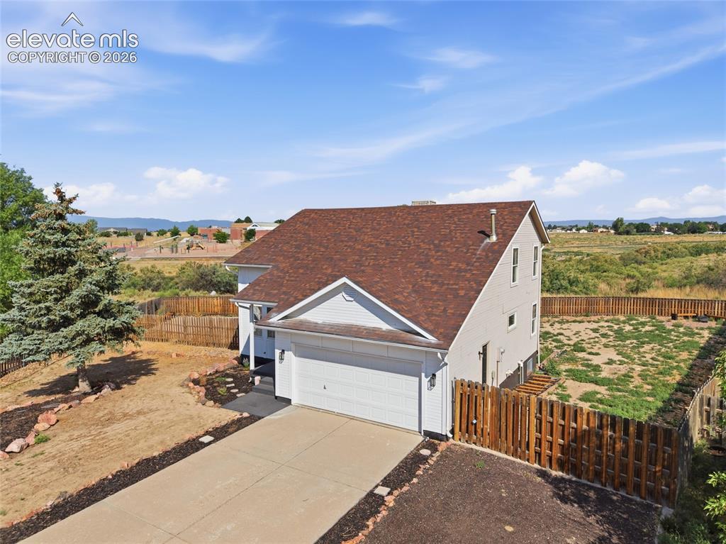Image 2 of 40: Two-story residence featuring a two-car garage, concrete driveway, and a wo