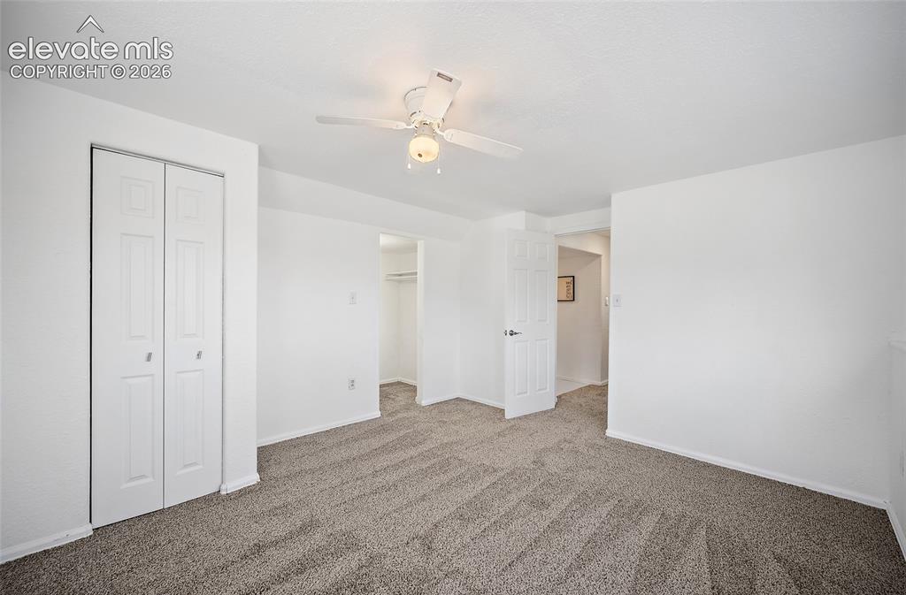 Image 24 of 40: Carpeted room with white walls, a ceiling fan, and a bi-fold closet