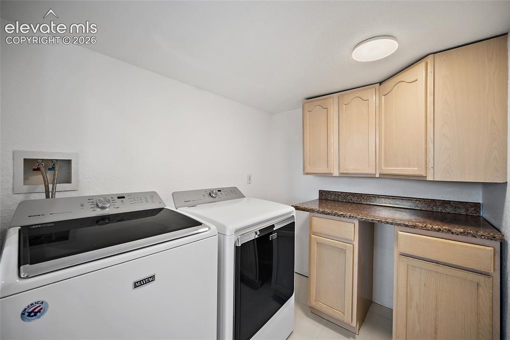 Image 28 of 40: Dedicated laundry area featuring a flush-mount ceiling light, light-toned c
