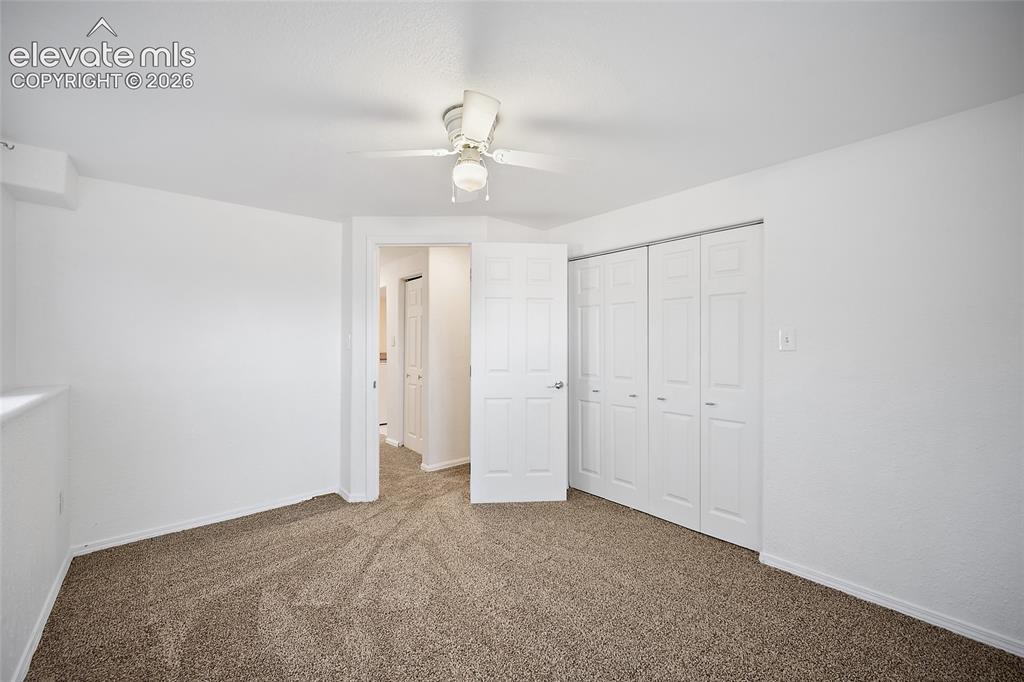 Image 29 of 40: Neutral-toned carpet flooring and white walls with a ceiling fan overhead