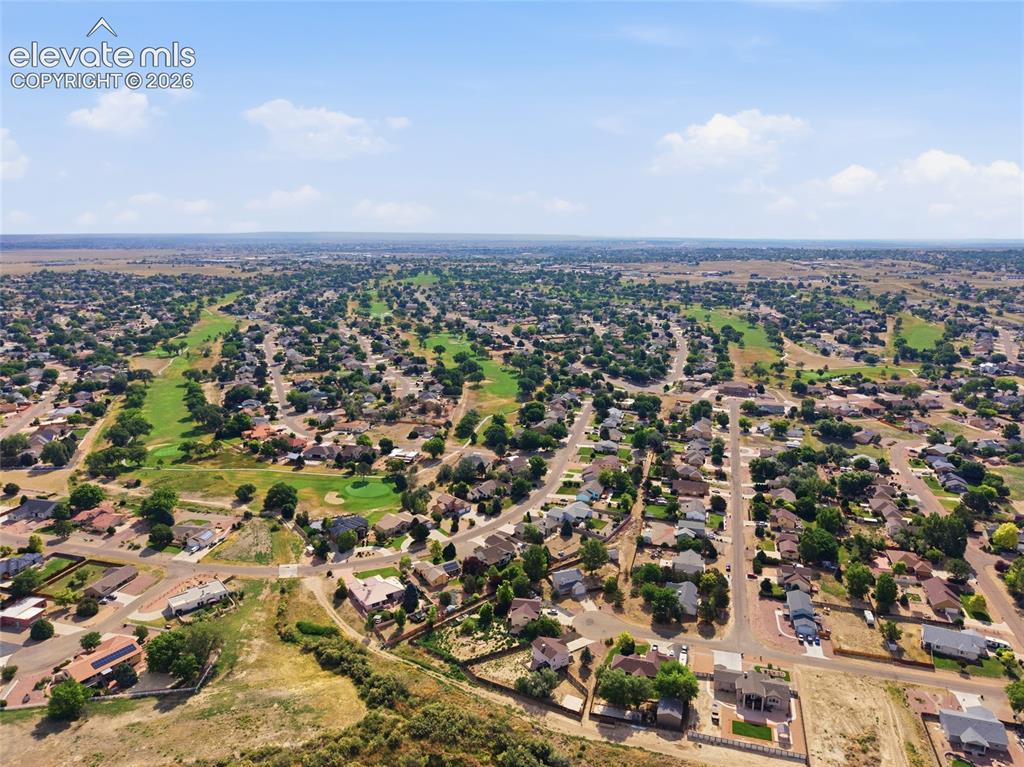 Image 36 of 40: Expansive aerial perspective showcasing a residential neighborhood with a g