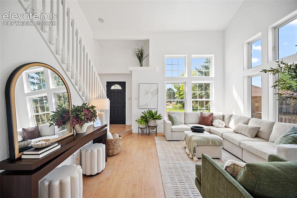 Image 4 of 40: Two-story living area featuring a vaulted ceiling and an abundance of natur