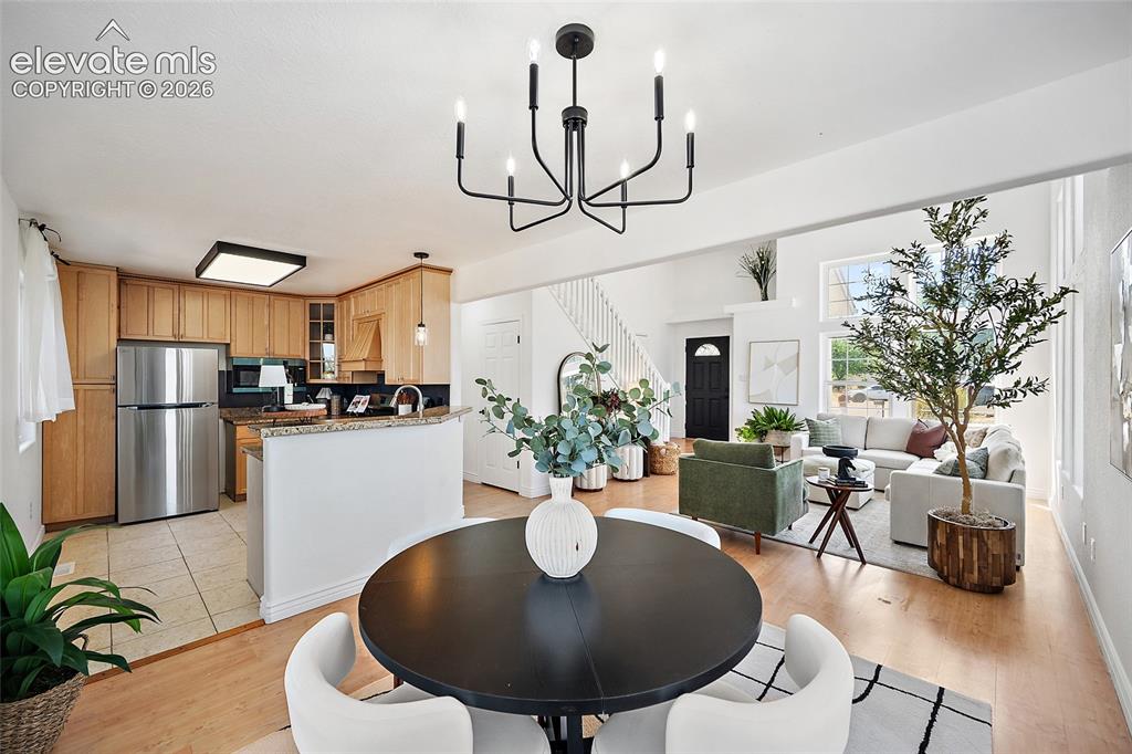 Image 7 of 40: Open-concept floor plan featuring a dining area with a modern chandelier, a