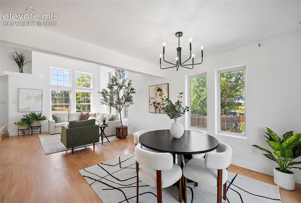 Image 8 of 40: Open-concept living and dining areas featuring wood-finish flooring, abunda