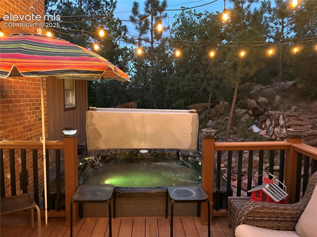 Image 15 of 42: Outdoor composite deck featuring a built-in hot tub, string lighting, in a 