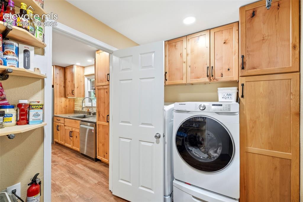 Image 26 of 42: Laundry room off the kitchen with built-ins