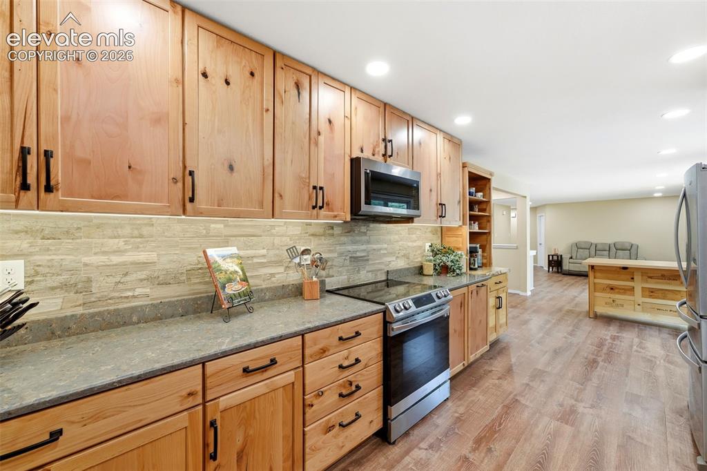 Image 8 of 42: Granite countertops and stacked tile backsplash