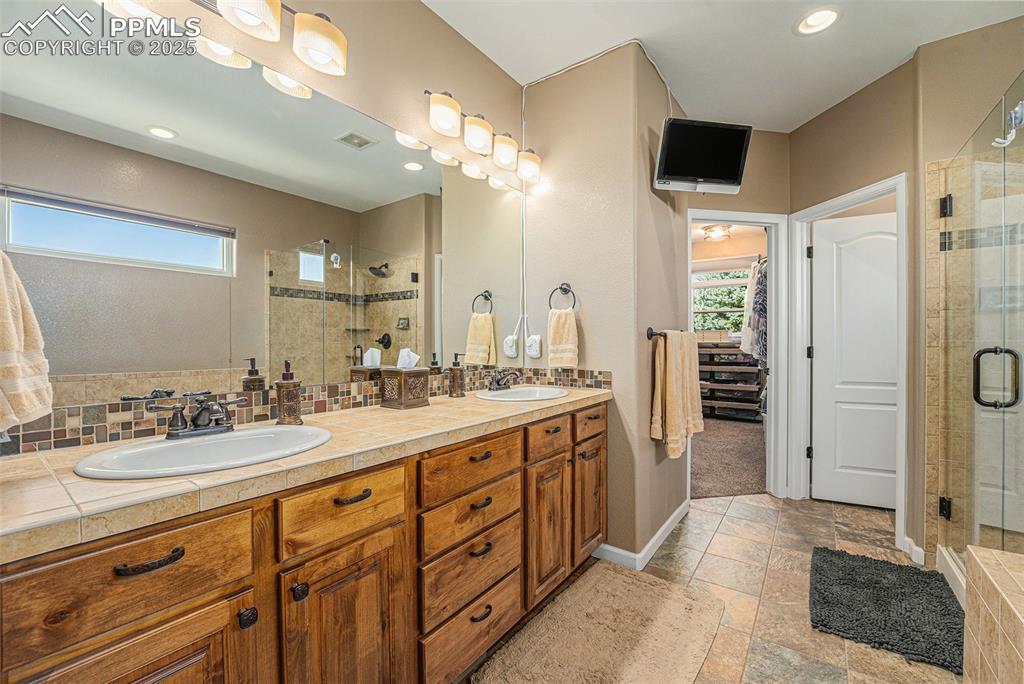 Image 15 of 48: Full bathroom with a shower stall, recessed lighting, backsplash, light sto