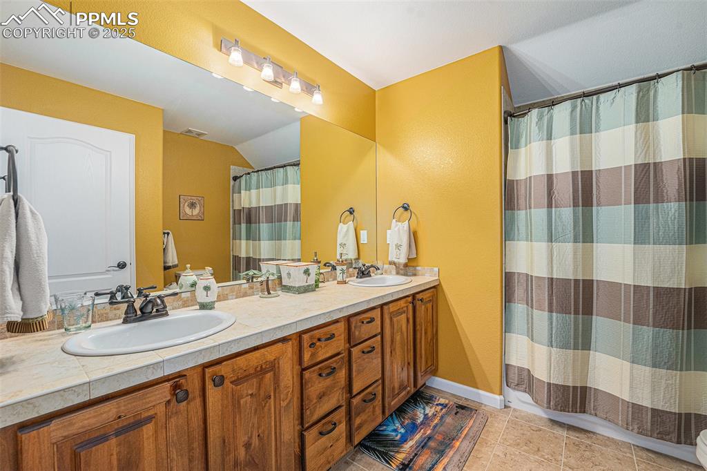 Image 23 of 48: Full bath with a sink and light tile patterned floors
