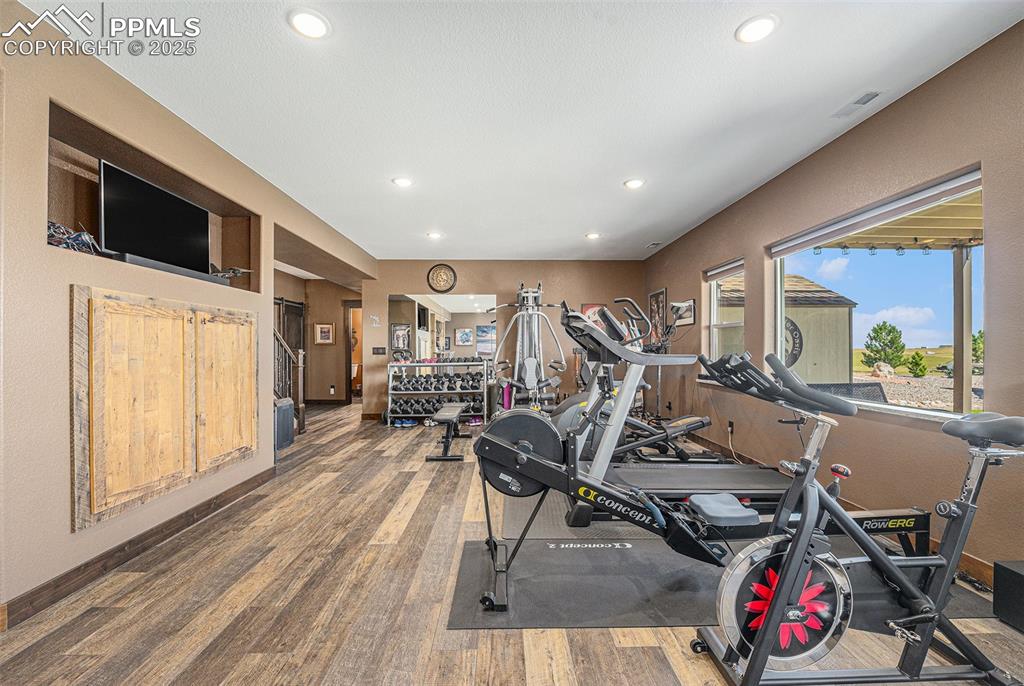 Image 27 of 48: Workout room with wood finished floors and recessed lighting