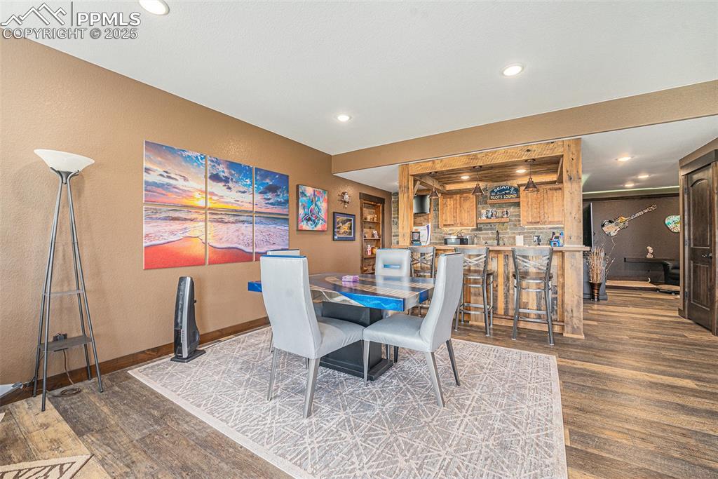 Image 28 of 48: Dining space with dark wood-style flooring, a textured wall, and recessed l