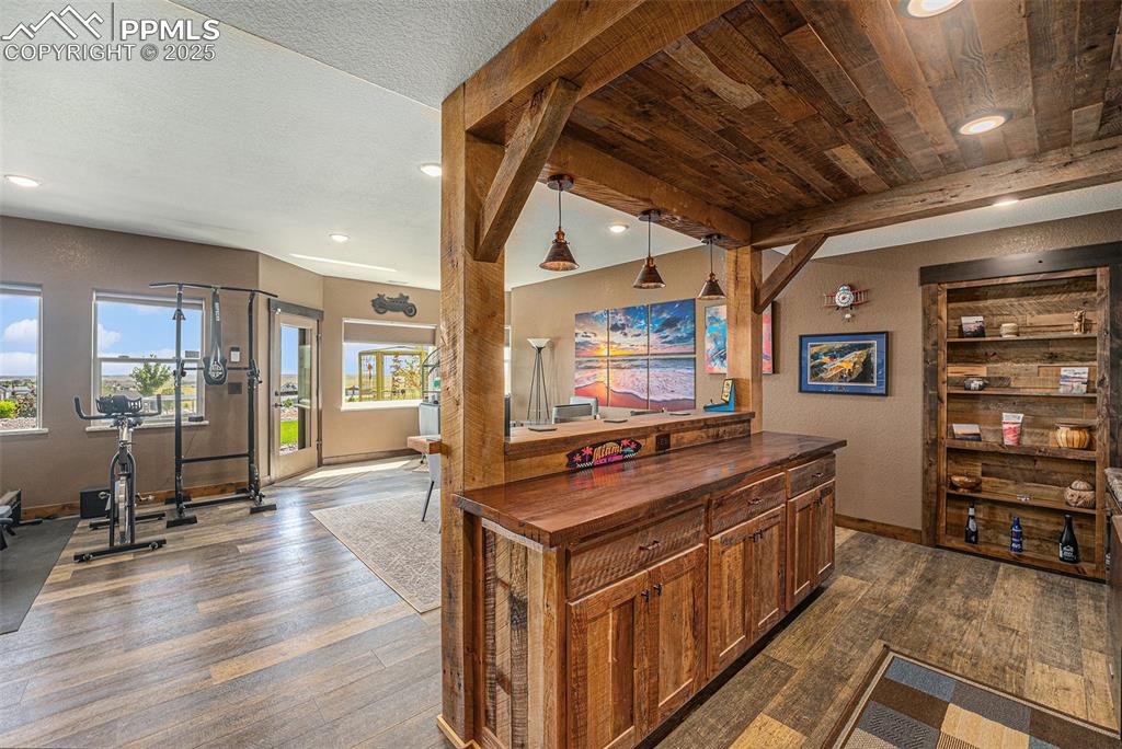 Image 31 of 48: Bar with wood counters, pendant lighting, dark wood-style flooring, beamed 
