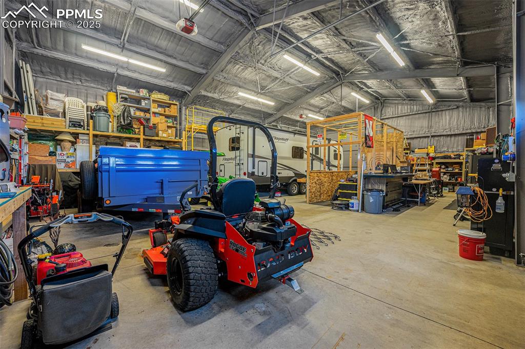 Image 35 of 48: Garage featuring metal wall and a workshop area