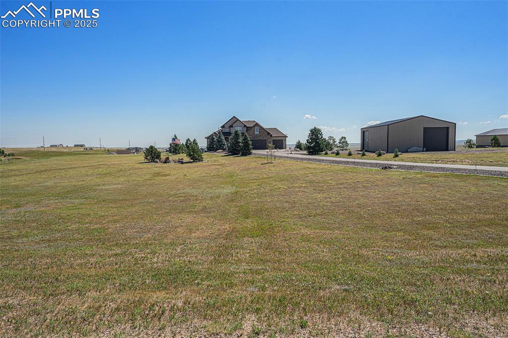 Image 41 of 48: View of green lawn with an outbuilding and a garage