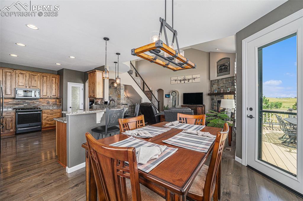 Image 8 of 48: Dining space with stairs, dark wood-type flooring, a fireplace, and recesse