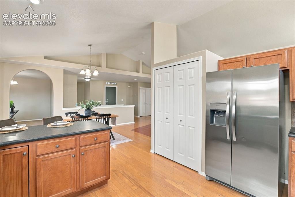 Image 14 of 50: Kitchen featuring wood-finish flooring, a kitchen island with dark countert
