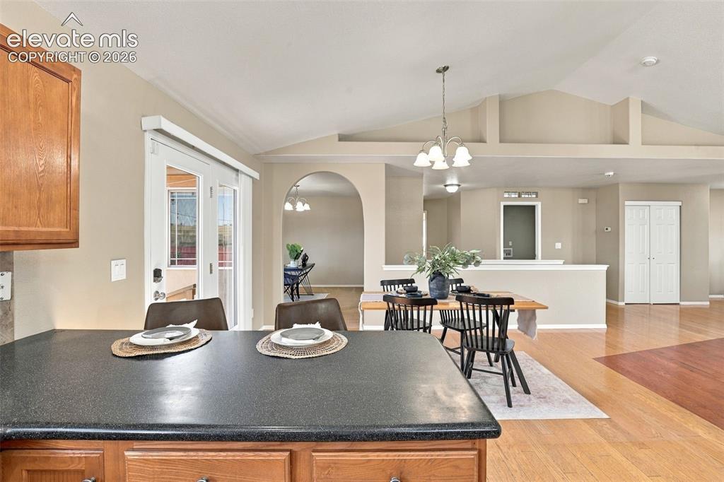 Image 15 of 50: Vaulted ceilings, wood-finish flooring, archway, and built-in bifold closet