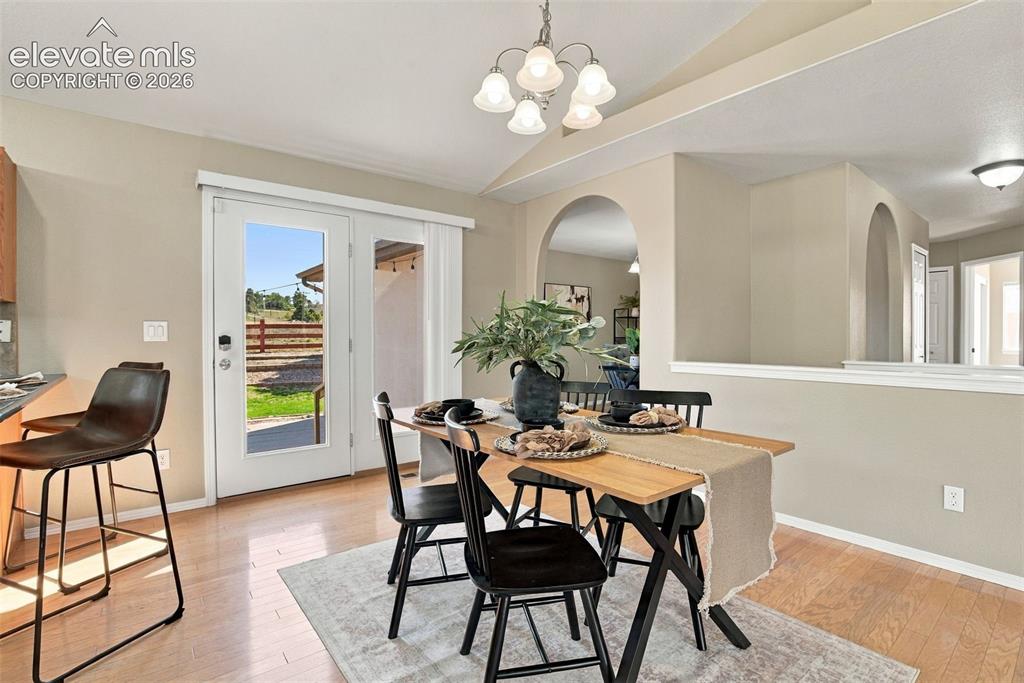 Image 18 of 50: Hardwood-style flooring, arched doorways, a built-in half wall with cap, an