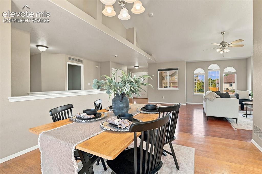 Image 19 of 50: Open-concept living space with vaulted ceilings, wood-finish flooring, and