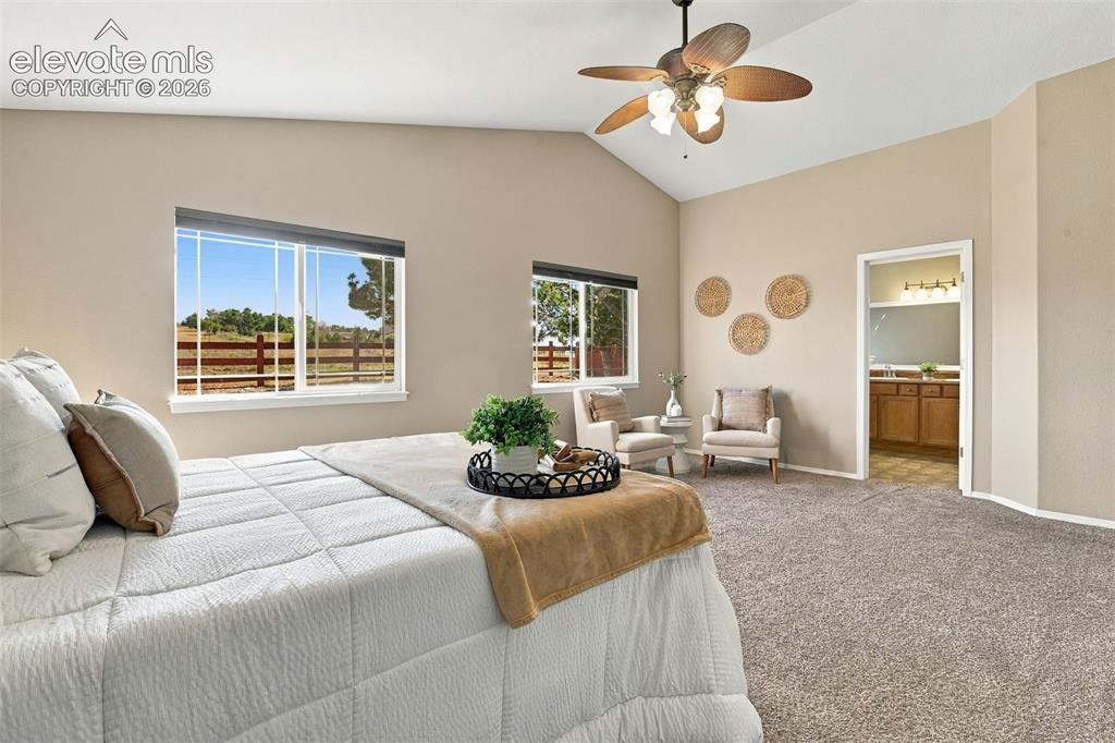 Image 24 of 50: Vaulted ceilings, a ceiling fan with integrated lighting, expansive windows