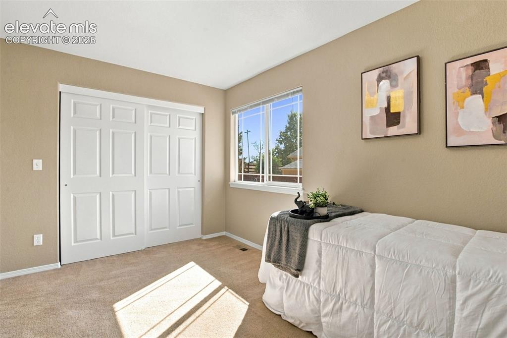 Image 28 of 50: Neutral tone wall paint with white trim, double pane window, carpeted floor