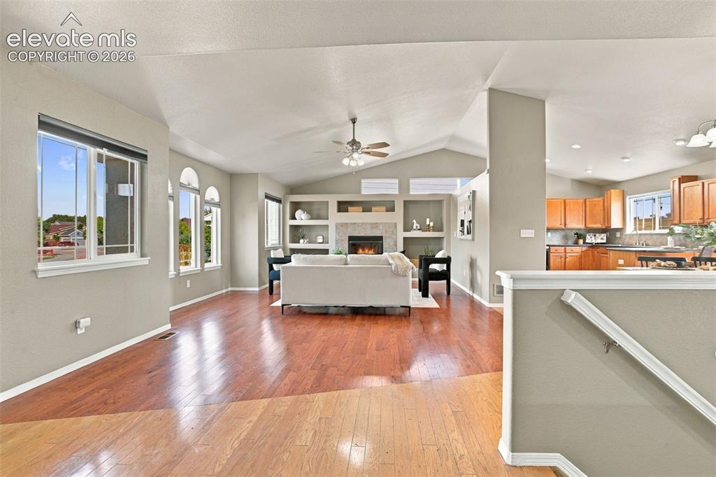 Image 3 of 50: Vaulted ceilings, wood-finish flooring, built-in shelving, stone-surround f