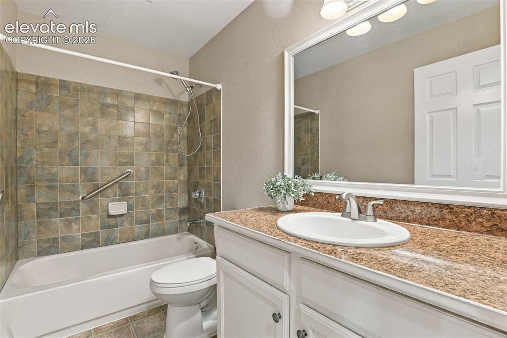 Image 30 of 50: Integrated bathtub and shower with stone-look tile surround